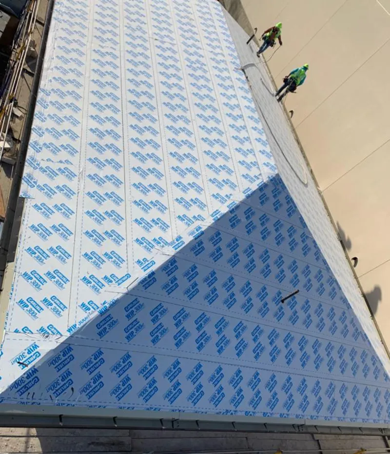 Professional roofers installing underlayment on a metal roof in Loves Park